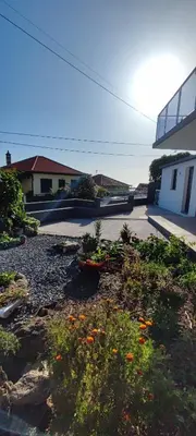 a garden with flowers in a yard next to a building at Casa Magic Vieira New well located with services in Arco da Calheta