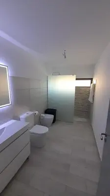 a bathroom with two toilets and a sink and a mirror at Casa Magic Vieira New well located with services in Arco da Calheta