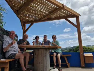 a group of people sitting at a table with drinks at Casinha do Barreiro - Cosy Private Cottage in Vila do Porto