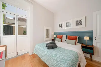 a bedroom with a bed with a blue and white bedspread at OurMadeira - Chill Garden Apartment in Funchal