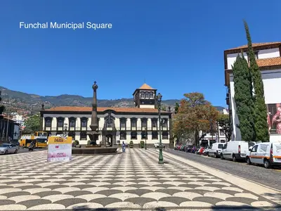 a building with a clock tower in the middle of a street at OurMadeira - Chill Garden Apartment in Funchal