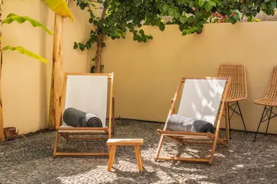 two mirrors sitting in rocking chairs next to a wall at OurMadeira - Chill Garden Apartment in Funchal
