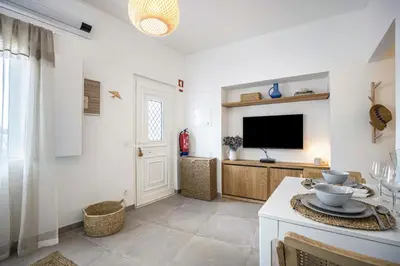a living room with a television and a table at Casa Mateus in Vila do Bispo