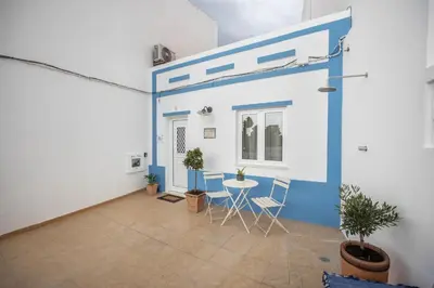 a room with a blue wall and a table and chairs at Casa Mateus in Vila do Bispo