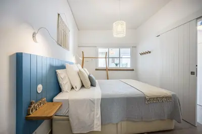 a bedroom with a large bed with a blue headboard at Casa Mateus in Vila do Bispo