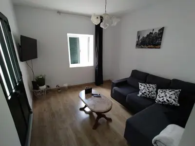 a living room with a black couch and a table at Downtown Tiny House in Funchal