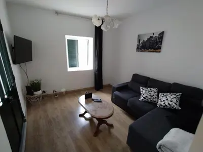 a living room with a black couch and a table at Downtown Tiny House in Funchal