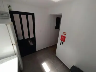 a white room with a door and a refrigerator at Downtown Tiny House in Funchal