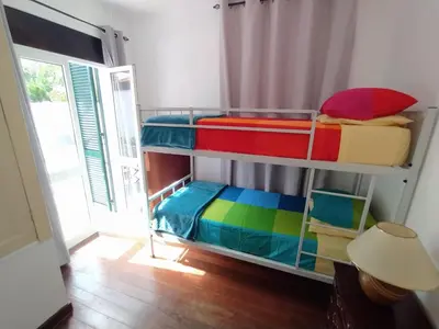 a room with two bunk beds with colorful sheets at Downtown Tiny House in Funchal