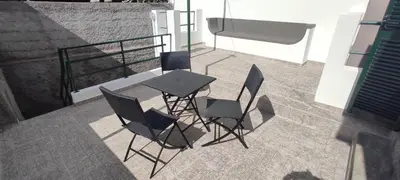 a table and chairs sitting on a balcony at Downtown Tiny House in Funchal