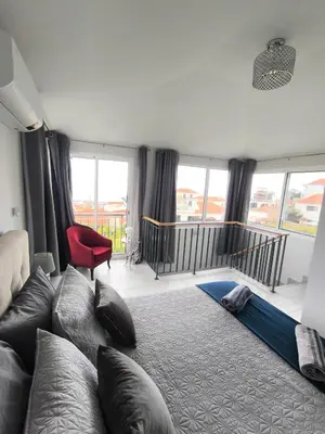 a bedroom with a large bed and a red chair at Downtown Tiny House in Funchal