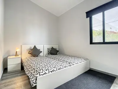 a white bedroom with a bed and a window at Casa da Avo by Atlantic Holiday in Caniçal