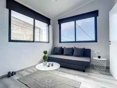 a living room with a couch and two windows at Casa da Avo by Atlantic Holiday in Caniçal