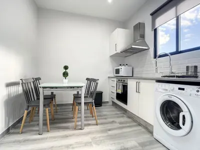 a kitchen with a table and a washing machine at Casa da Avo by Atlantic Holiday in Caniçal