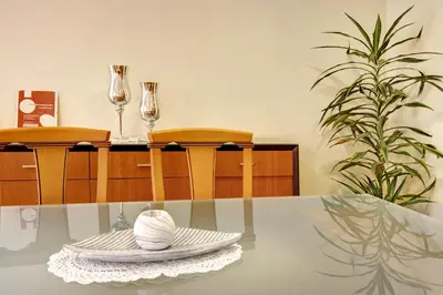 a kitchen with wooden cabinets and a wooden table at Vinháticos House in São Vicente