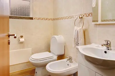a bathroom with a toilet and a sink at Vinháticos House in São Vicente
