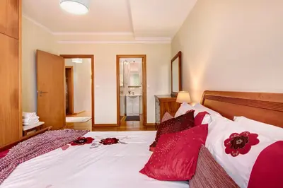 a bedroom with a bed with red pillows on it at Vinháticos House in São Vicente