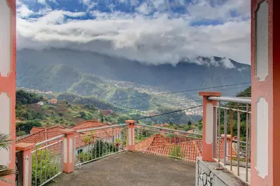 a balcony with a view of a mountain at Vinháticos House in São Vicente