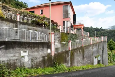 a pink house on the side of a wall at Vinháticos House in São Vicente