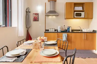 a kitchen with a wooden table with chairs and a dining room at Calheta Lofts I in Calheta