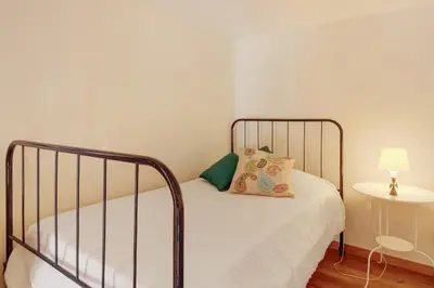 a bedroom with a bed and a lamp on a table at Calheta Lofts I in Calheta