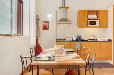 a kitchen with a wooden table with chairs around it at Calheta Lofts ii in Calheta