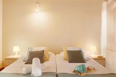 a bedroom with two beds with towels and two lamps at Calheta Lofts ii in Calheta