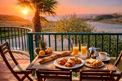 a table with a breakfast of croissants and orange juice at Casa Da luz 5 - st james apt 2 bedrooms , Amazing sea view , pool , wifi in Luz