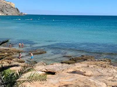 a group of people in the water at a beach at Casa Da luz 5 - st james apt 2 bedrooms , Amazing sea view , pool , wifi in Luz