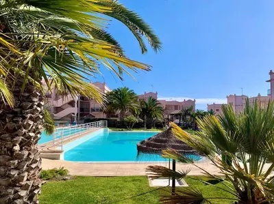 a swimming pool in a resort with a palm tree at Casa Da luz 5 - st james apt 2 bedrooms , Amazing sea view , pool , wifi in Luz