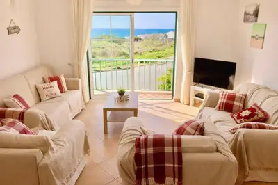 a living room with two couches and a view of the ocean at Casa Da luz 5 - st james apt 2 bedrooms , Amazing sea view , pool , wifi in Luz