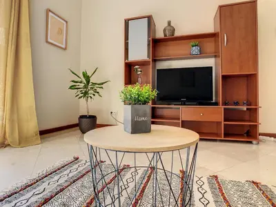 a living room with a table and a tv at Theos Apartment by LovelyStay in Funchal