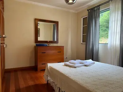 a bedroom with a bed and a dresser and a mirror at Briola by AnaLodges in São Vicente