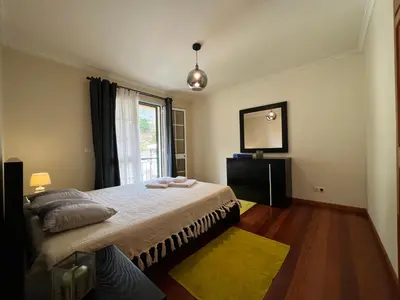 a bedroom with a bed and a mirror and a window at Briola by AnaLodges in São Vicente