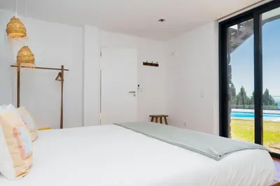 a bedroom with a bed with palm trees on the wall at Unmei by LovelyStay in Caniço