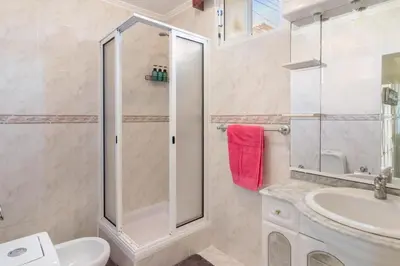 a bathroom with a shower and a toilet and a sink at Home Away From Home in Caniçal