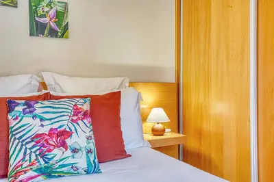 a bedroom with a bed with a pillow and a lamp at Vilamar 2 - Madeira Inn Group in Calheta