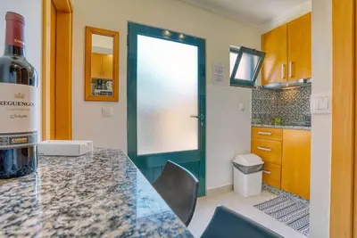 a kitchen with a table with a bottle of wine at Vilamar 2 - Madeira Inn Group in Calheta