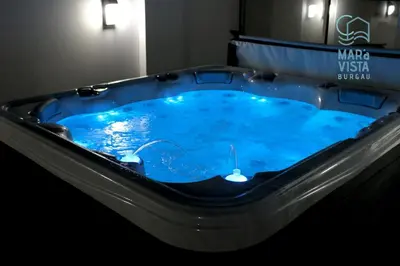a jacuzzi tub with blue water in a room at Mar à Vista Burgau in Burgau