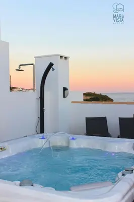 a hot tub in a room with a view of the ocean at Mar à Vista Burgau in Burgau