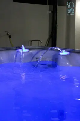a bath tub filled with blue water in a room at Mar à Vista Burgau in Burgau