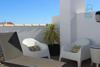 two white chairs and a laptop on a balcony at Mar à Vista Burgau in Burgau