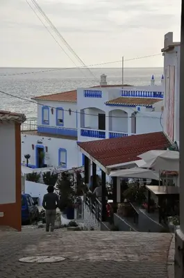 a man walking down a street in front of a building at Mar à Vista Burgau in Burgau