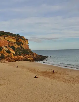 a group of people laying on a beach near the ocean at Mar à Vista Burgau in Burgau
