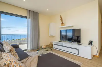 a living room with a large flat screen tv at Canhas Residence I by Homie in Ponta do Sol