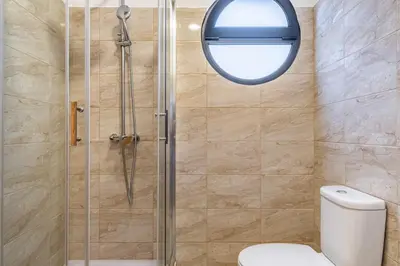 a bathroom with a shower with a toilet and a window at Canhas Residence I by Homie in Ponta do Sol