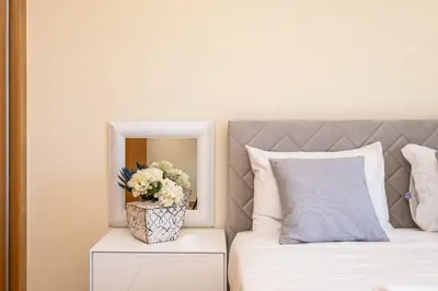 a bedroom with a bed with a mirror and a vase of flowers at Canhas Residence I by Homie in Ponta do Sol