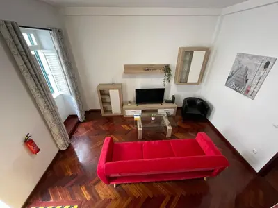 a living room with a red couch and a table at Fort Traditional Guest House in Funchal