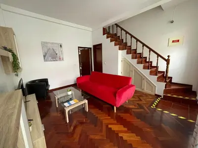 a living room with a red couch and stairs at Fort Traditional Guest House in Funchal