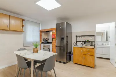 a kitchen with a table and a refrigerator at Casa da Hortência do Faial in Faial